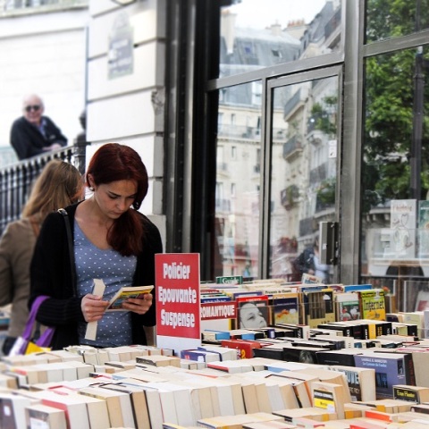 Γυναίκα διαβάζει βιβλίο σε βιβλιοπωλείο στη Γαλλία