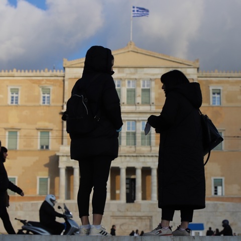Πολίτες συζητούν με φόντο τη Βουλή των Ελλήνων