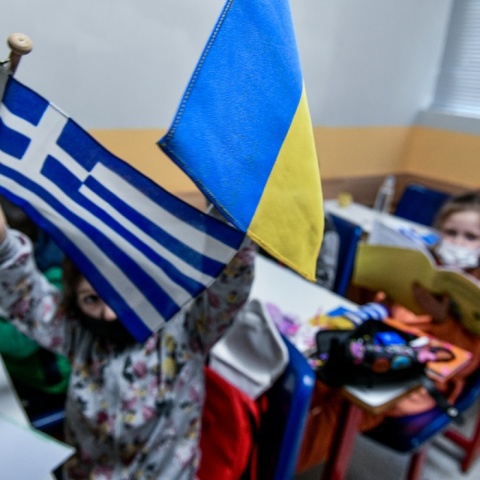 Παιδιά- πρόσφυγες από την Ουκρανία κρατούν την ελληνική και την ουκρανική σημαία σε χώρο όπου μαθαίνουν ελληνικά στο κέντρο της Αθήνας