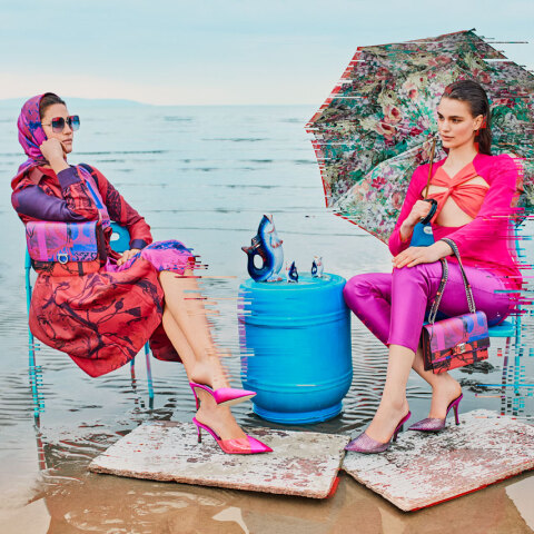 Γυναίκες με χρωματιστά ρούχα καθισμένες σε καρέκλες σε παραλία