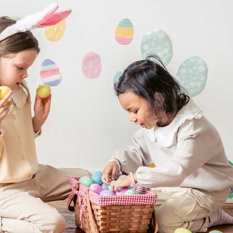 Δύο μικρά κορίτσια παίζουν με πασχαλινά αυγά