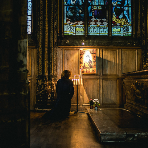 Γυναίκα προσεύχεται μέσα στην εκκλησία