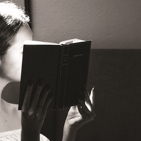 Ένα κορίτσι κρατάει ένα βιβλίο.