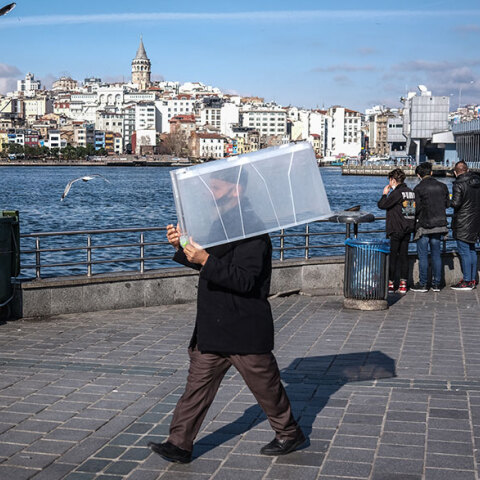 Άνδρας με μάσκα για τον κορωνοϊό στην Κωνσταντινούπολη μεταφέρει ένα πλαστικό κουτί