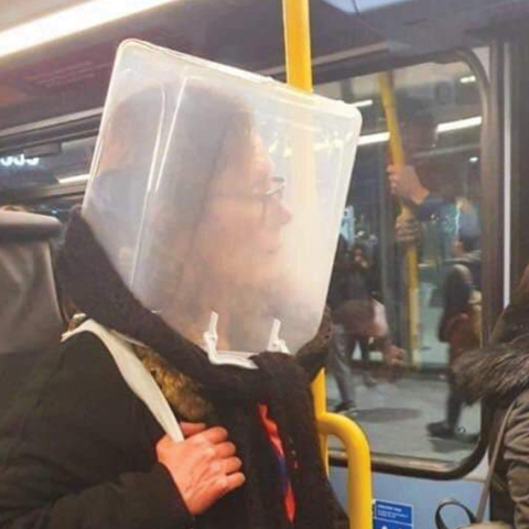 Γυναίκα μέσα στο μετρό που φοράει κουβά στο κεφάλι