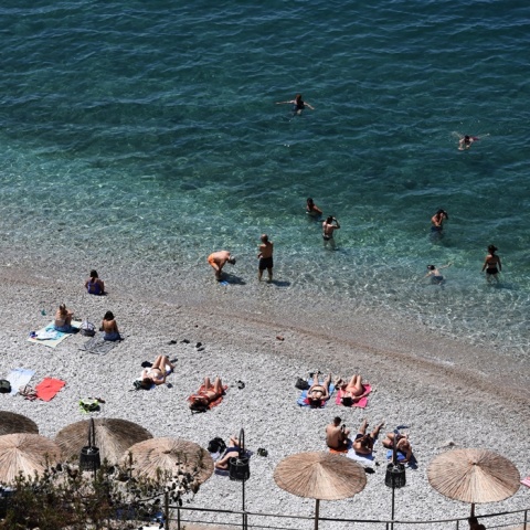 Λουόμενοι σε παραλία για να δροσιστούν από τις υψηλές θερμοκρασίες - Πολίτες απολαμβάνουν τη θάλασσα, όσο άλλοι κάνουν ηλιοθεραπεία