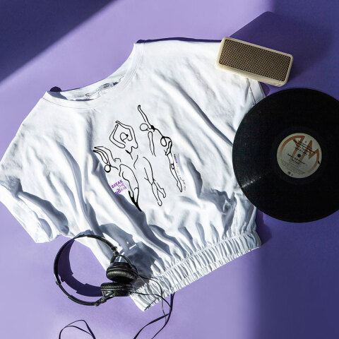 Αντικείμενα (μπλουζάκι, δίσκος βινυλίου, ακουστικά, ηχείο) ακουμπισμένα σε μωβ φόντο