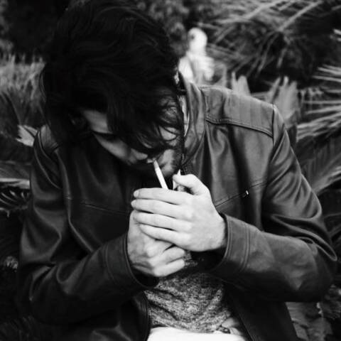 Ασπρόμαυρη φωτογραφία άντρα που καπνίζει