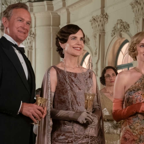 Downtown Abbey - Σκηνή από την ταινία όπου άνδρας και γυναίκες που κρατούν ποτά 