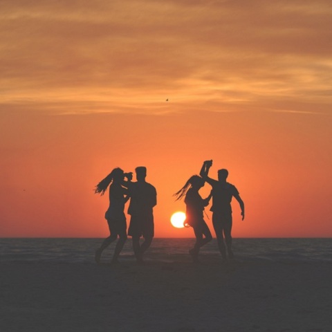 Τέσσερα άτομα χορεύουν στην παραλία. 