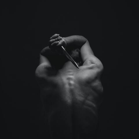 Άτομο κρατά πίσω από την πλάτη του μαχαίρι