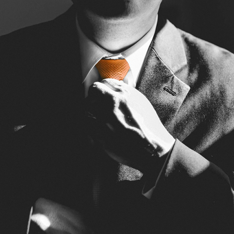 Άντρας με κοστούμι που φτιάχνει τη γραβάτα του