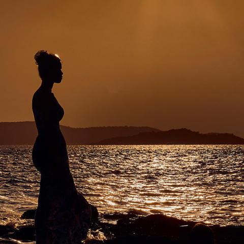 Ένα κορίτσι ποζάρει στο ηλιοβασίλεμα. 