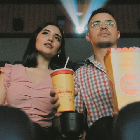 Δύο άτομα βλέπουν μια ταινία στον κινηματογράφο.