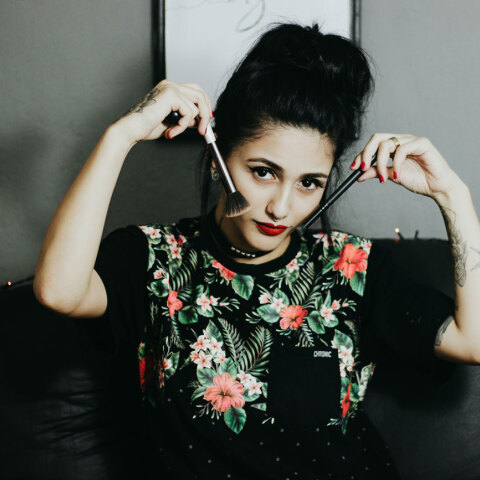 Γυναίκα κρατάει πινέλα δίπλα στα μάγουλά της