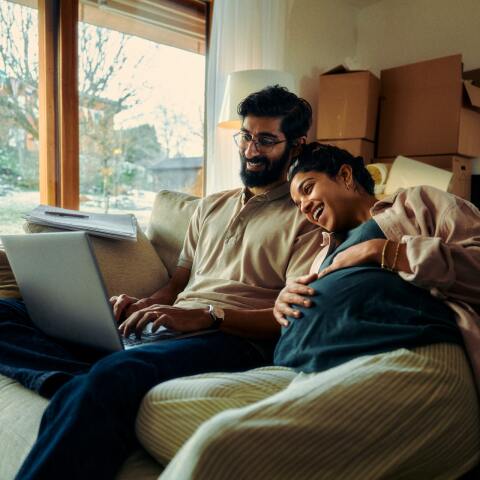 Άνδρας με έγκυο γυναίκα κοιτούν laptop