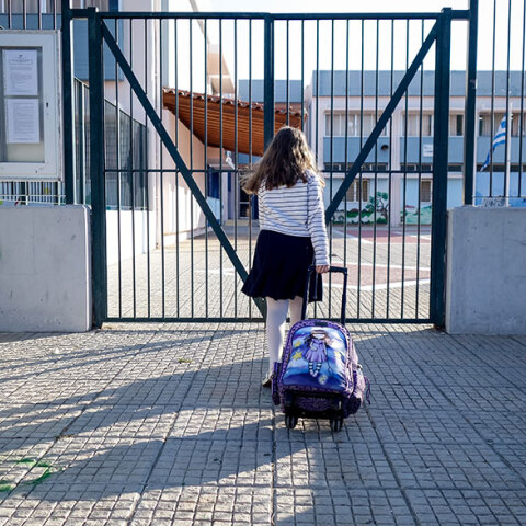 Κοριτσάκι με τη σχολική του τσάντα έξω από σχολείο 