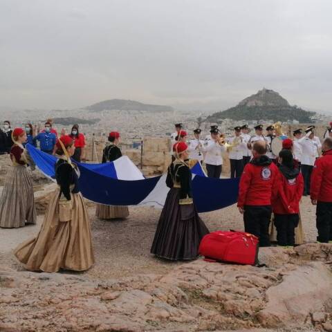 Κοπέλες από το Λύκειο των Ελληνίδων μεταφέρουν τη σημαία της Απελευθέρωσης στον ιερό βράχο της Ακρόπολης