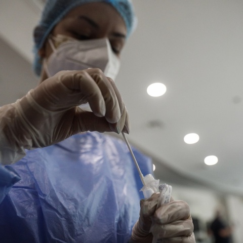 Γυναίκα κρατά στα χέρια της το υγρό και το στιλέο για rapid test