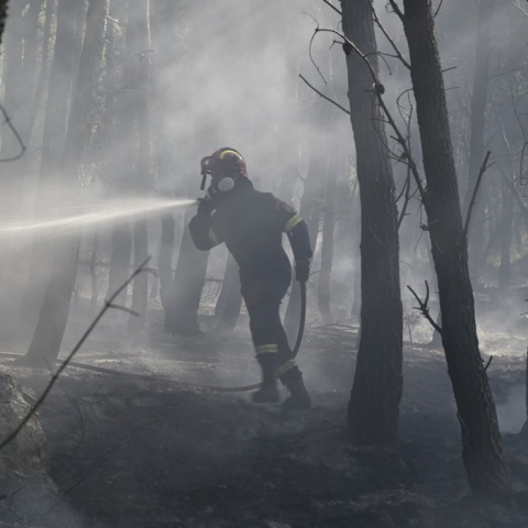 Πυροσβέστης πίσω από καπνούς από την πυρκαγιά