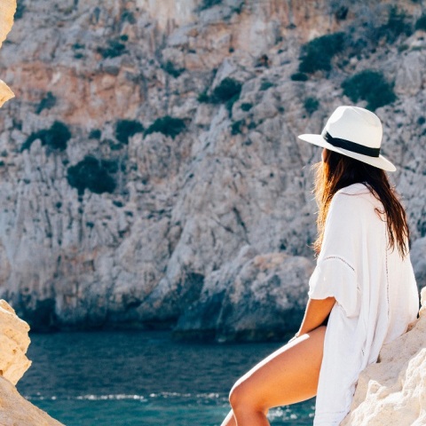 Ένα κορίτσι στα βράχια της παραλίας. 