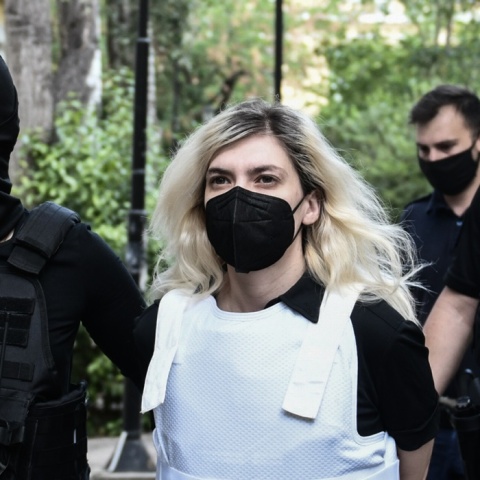Η Ρούλα Πισπιρίγκου κατά τη μεταγωγή της στον εισαγγελέα φορά μάσκα και αλεξίσφαιρο γιλέκο