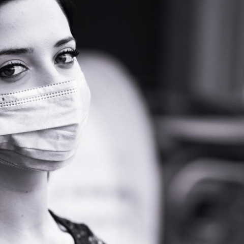 Ασπρόμαυρη φωτογραφία γυναίκας που φοράει χειρουργική μάσκα