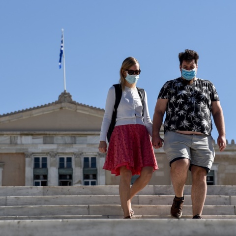 Ζευγάρι με μάσκα κατεβαίνει τα σκαλιά στην πλατεία Συντάγματος