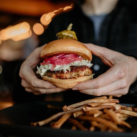 Fast Food - Burger που το κρατά μία γυναίκα και πατάτες