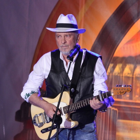 Ο Ρόμπερτ Ουίλιαμς κρατά την κιθάρα του σε συναυλία το 2018