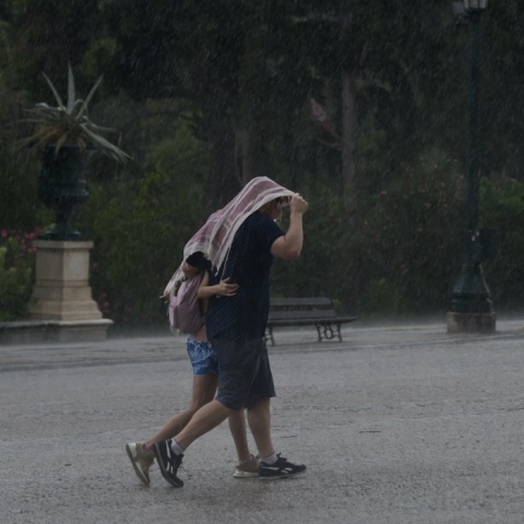 Καταιγίδα στην Αθήνα - Αγκαλιασμένοι πολίτες κάτω από ύφασμα