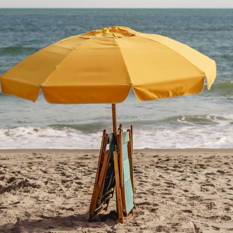 Ομπρέλα ανοιχτή σε παραλία με δύο ομπρέλες μαζεμένες