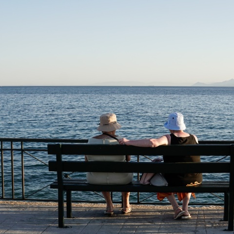 Δύο ηλικιωμένες κυρίες ατενίζουν τη θάλασσα από παγκάκι
