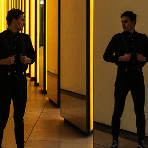 Άντρας ντυμένος στα μαύρα, που κοιτιέται στον καθρέφτη