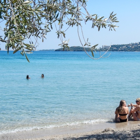 Γυναίκες με μαγιό στην ακροθαλασσιά απολαμβάνουν τον ήλιο