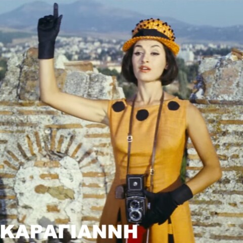 Η Μάρθα Καραγιάννη με φωτογραφική στα χέρια δίνει το σήμα για λήψη υψώνοντας το δεξί της χέρι