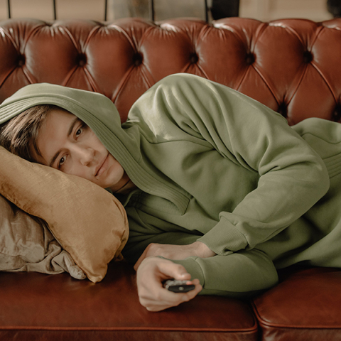 Άντρας στον καναπέ, βλέπει τηλεόραση