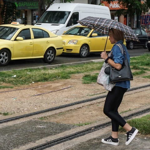 Γυναίκα με ομπρέλα περπατά σε δρόμο