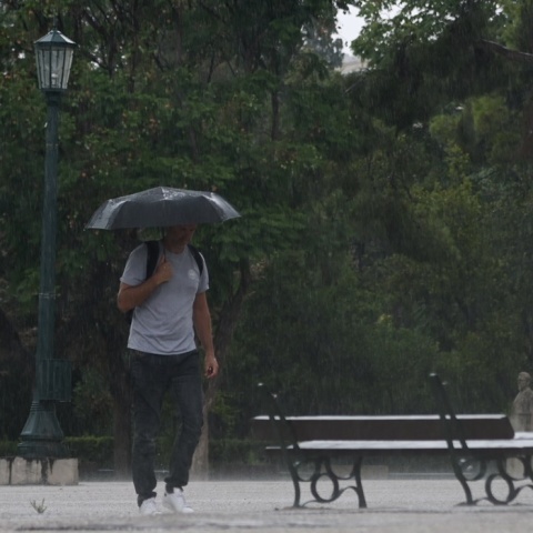 Άνδρας κρατά ομπρέλα για να προστατευτεί από καταιγίδα