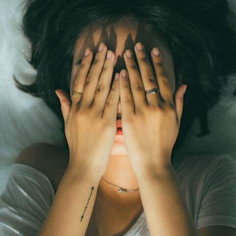 Κοπέλα κρύβει το πρόσωπό της με τα χέρια