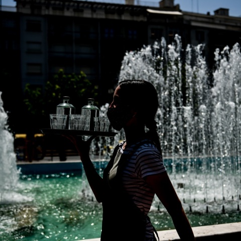 Η σκιά εργαζόμενης στον χώρο της εστίασης μπροστά από σιντριβάνι