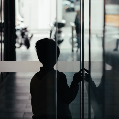 Ανήλικος πίσω από πόρτα κοιτά προς τον δρόμο