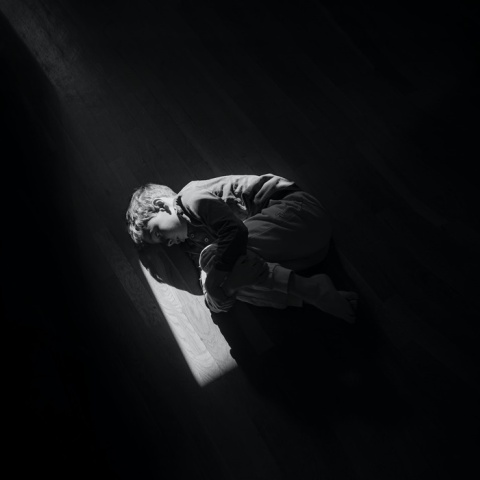 Παιδί ξαπλωμένο σε εμβρυακή στάση στο πάτωμα