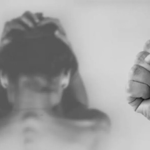 Άνδρας με σφιγμένη γροθιά και γυναίκα που προσπαθεί να προστατευτεί