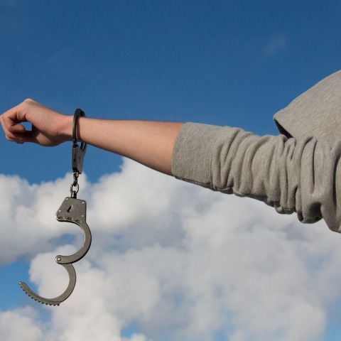 Νεαρός προτάσσει τις λυμένες χειροπέδες του