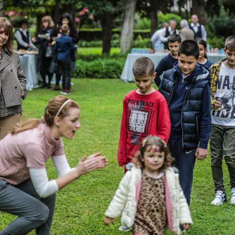 Η Κατερίνα Σακελλαροπούλου χαμογελά βλέποντας τα παιδιά του Χωριού SOS Βάρης να παίζουν στον κήπο του Προεδρικού Μεγάρου