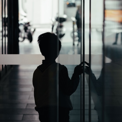 Αγόρι σε σκοτεινό διάδρομο κοιτά προς την έξοδο