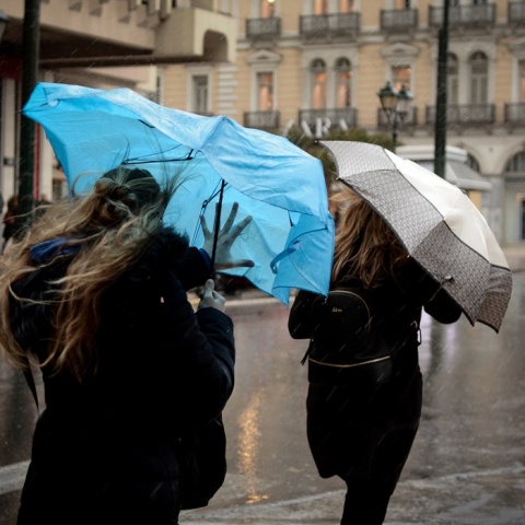 Γυναίκες κρατούν ομπρέλες για να προστατευτούν από καταιγίδα και τις παίρνει ο αέρας