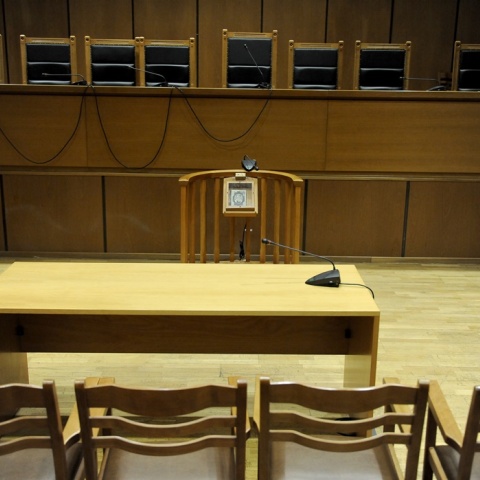 Αίθουσα δικαστηρίου χωρίς κόσμο με κενά έδρανα