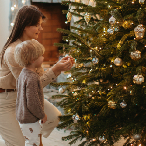 Μαμά και παιδί στολίζουν χριστουγεννιάτικο δέντρο